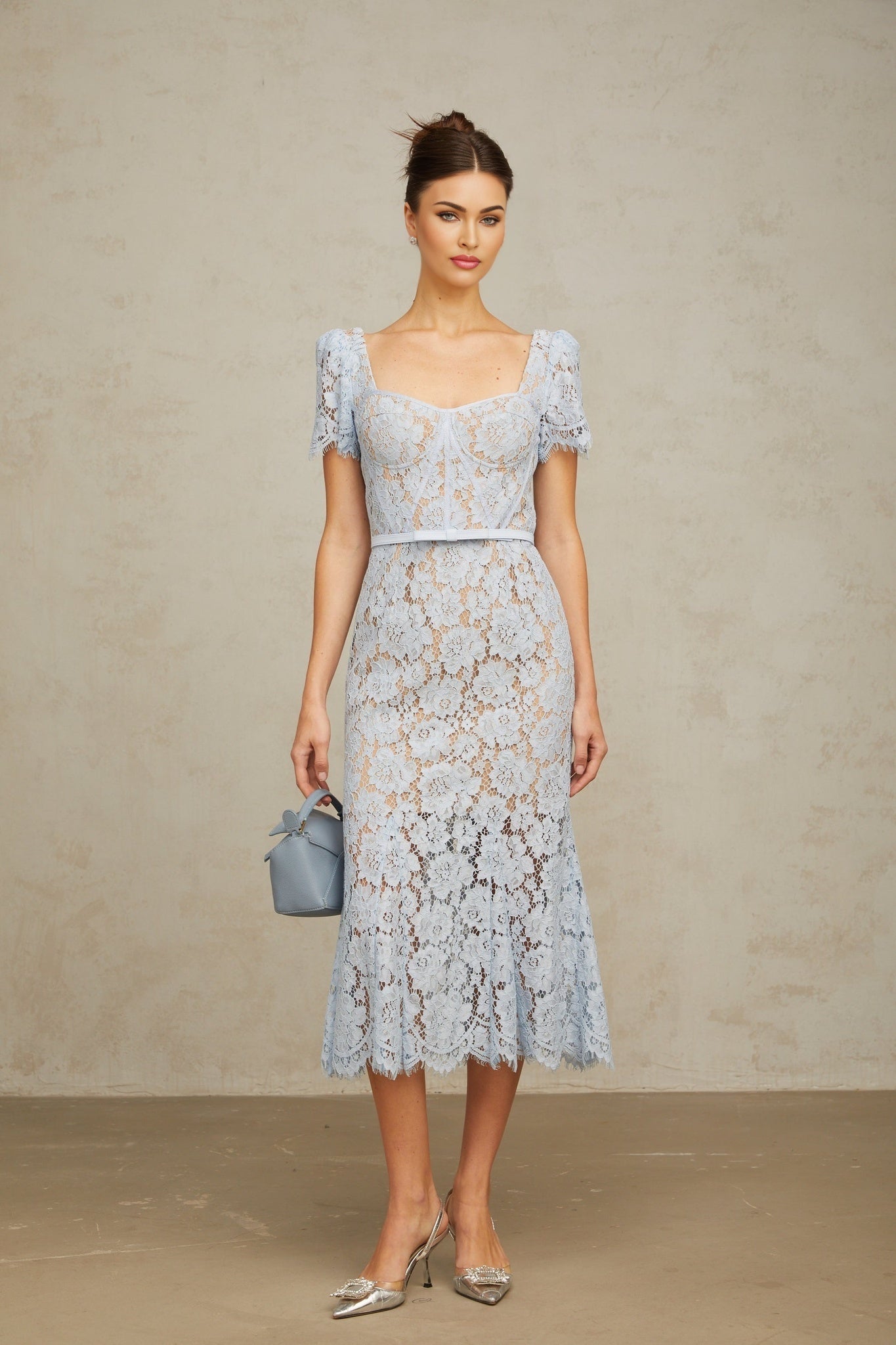 Woman wearing blue floral lace midi dress with boned bodice and fitted silhouette