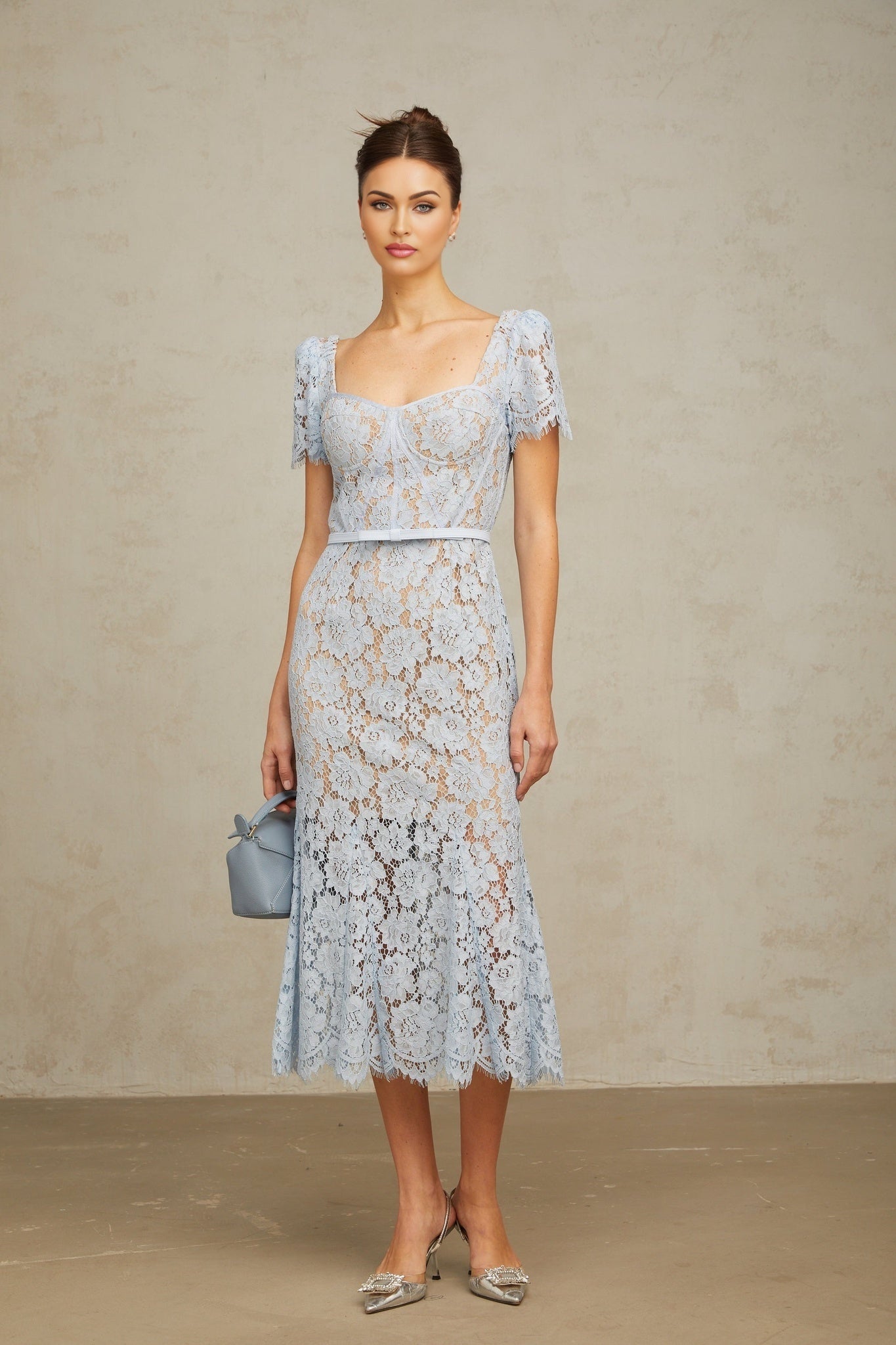 Woman wearing blue floral lace midi dress with boned bodice and thin straps