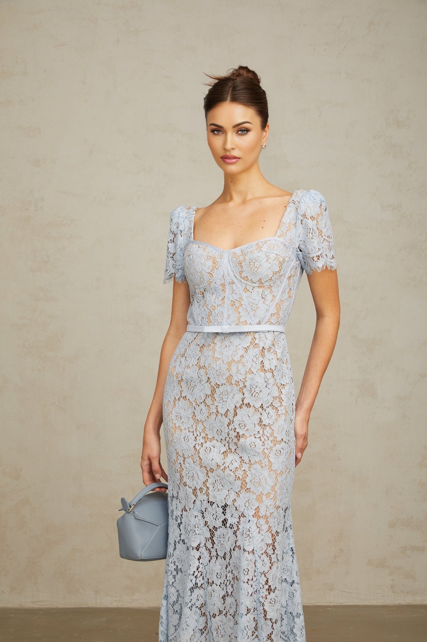 Woman wearing blue floral lace midi dress with boned bodice fitted waist and delicate straps