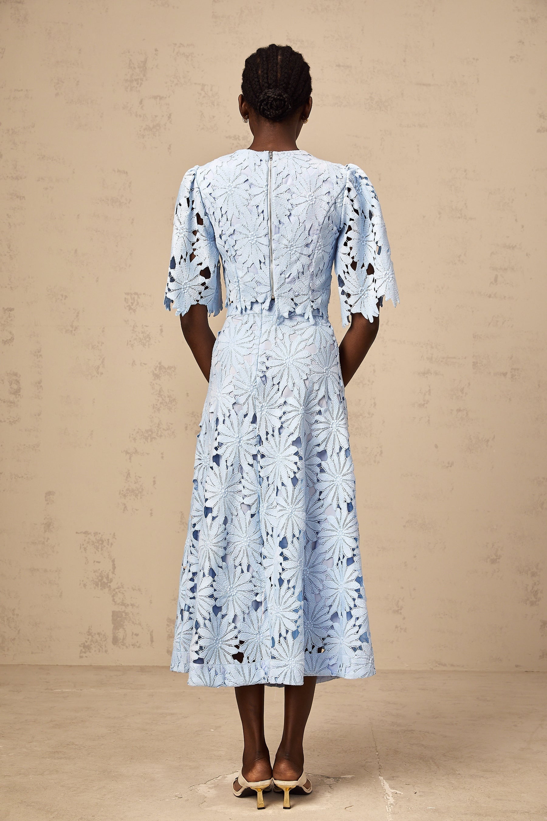 Woman wearing blue lace top and matching skirt set in Audrey style with guipure lace pattern
