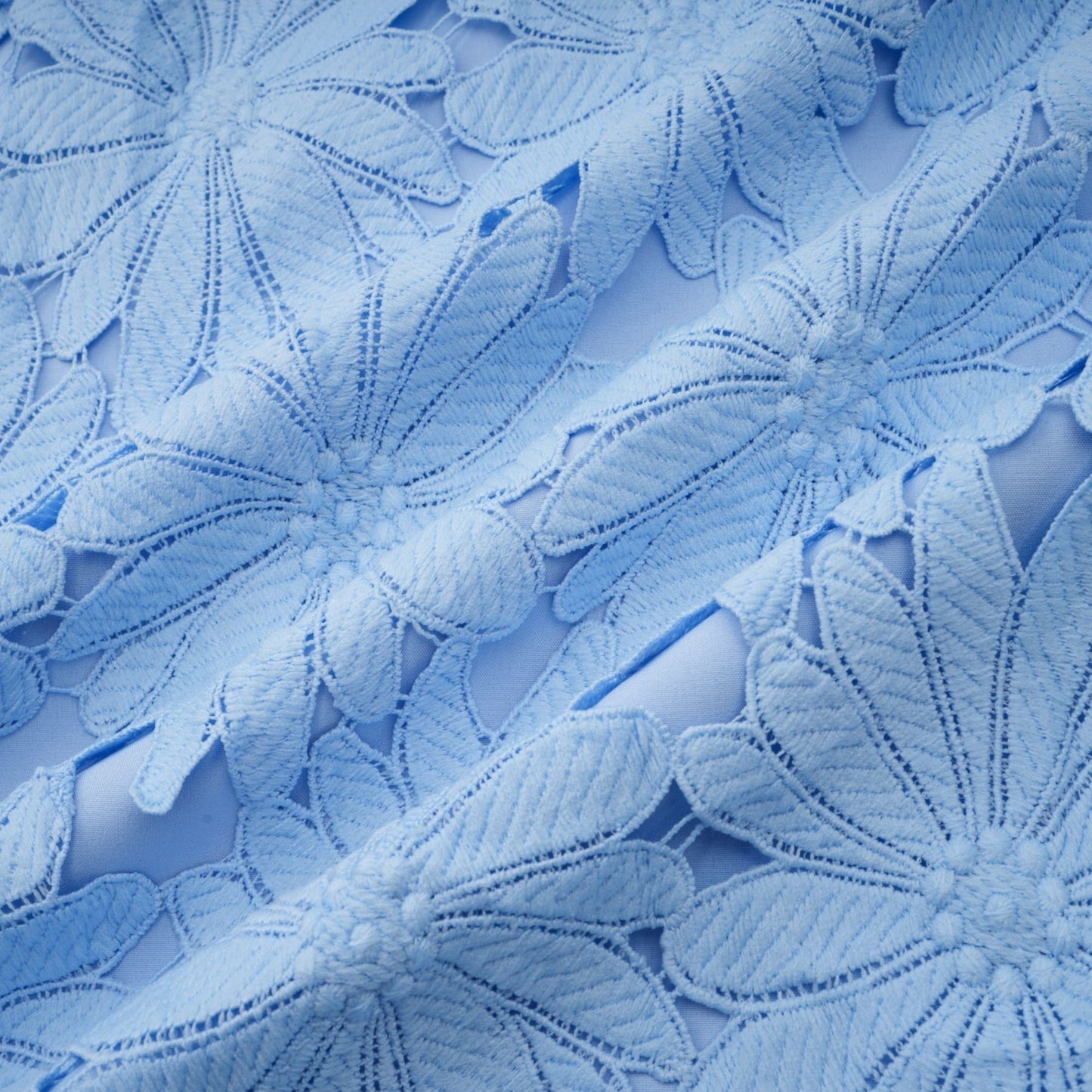 Woman wearing blue lace top and matching skirt set with guipure pattern elegant two piece outfit for formal occasions
