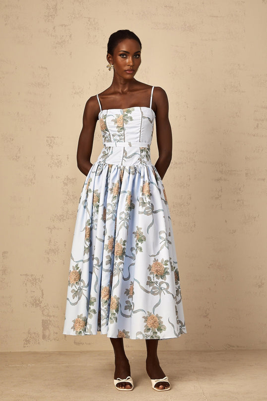 Woman wearing blue midi dress with floral print pattern