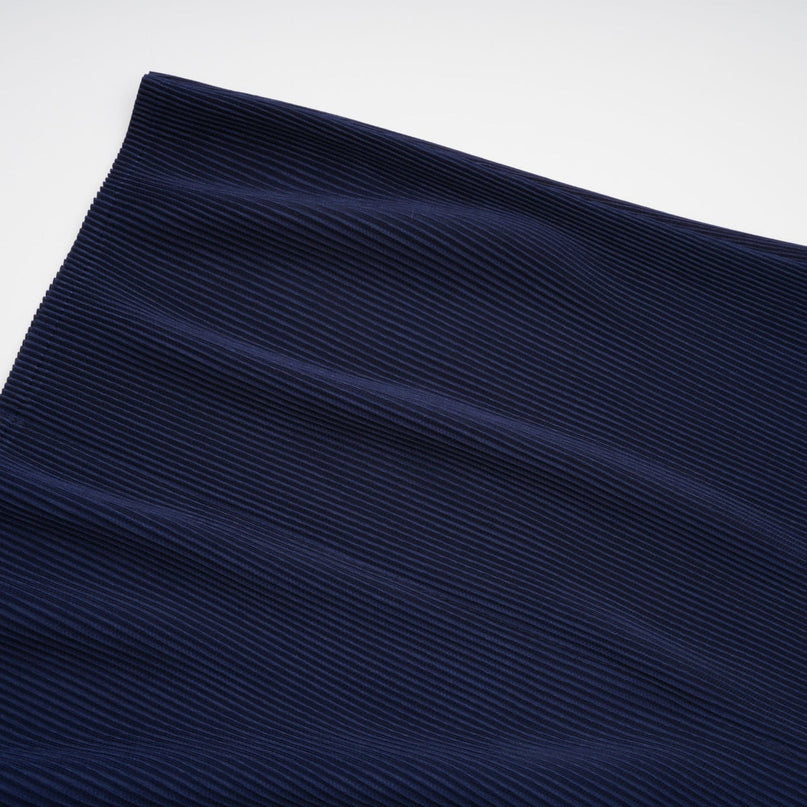 Woman wearing blue patterned cape and matching skirt set with crease details Debbie design