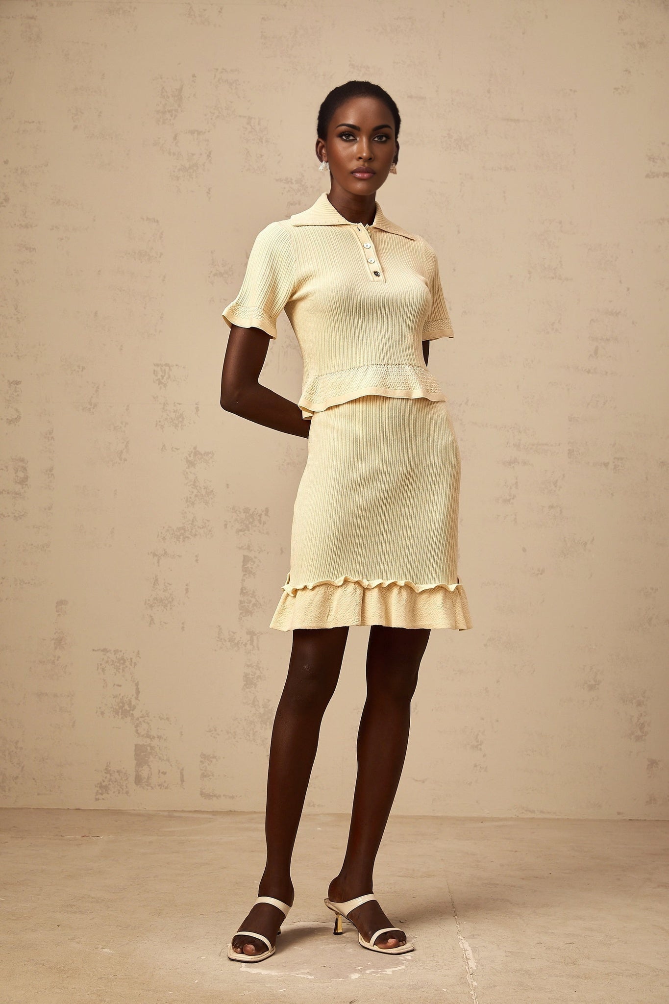 Woman wearing bright yellow matching set consisting of ruffled ribbed knit top and skirt