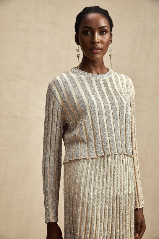 Woman wearing champagne colored striped knit top and matching skirt set