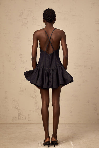 Woman wearing dark blue denim mini dress with flounce detail