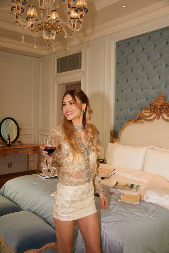 Woman wearing delicate floral beaded sheer organza jacket in light color elegant luxurious style