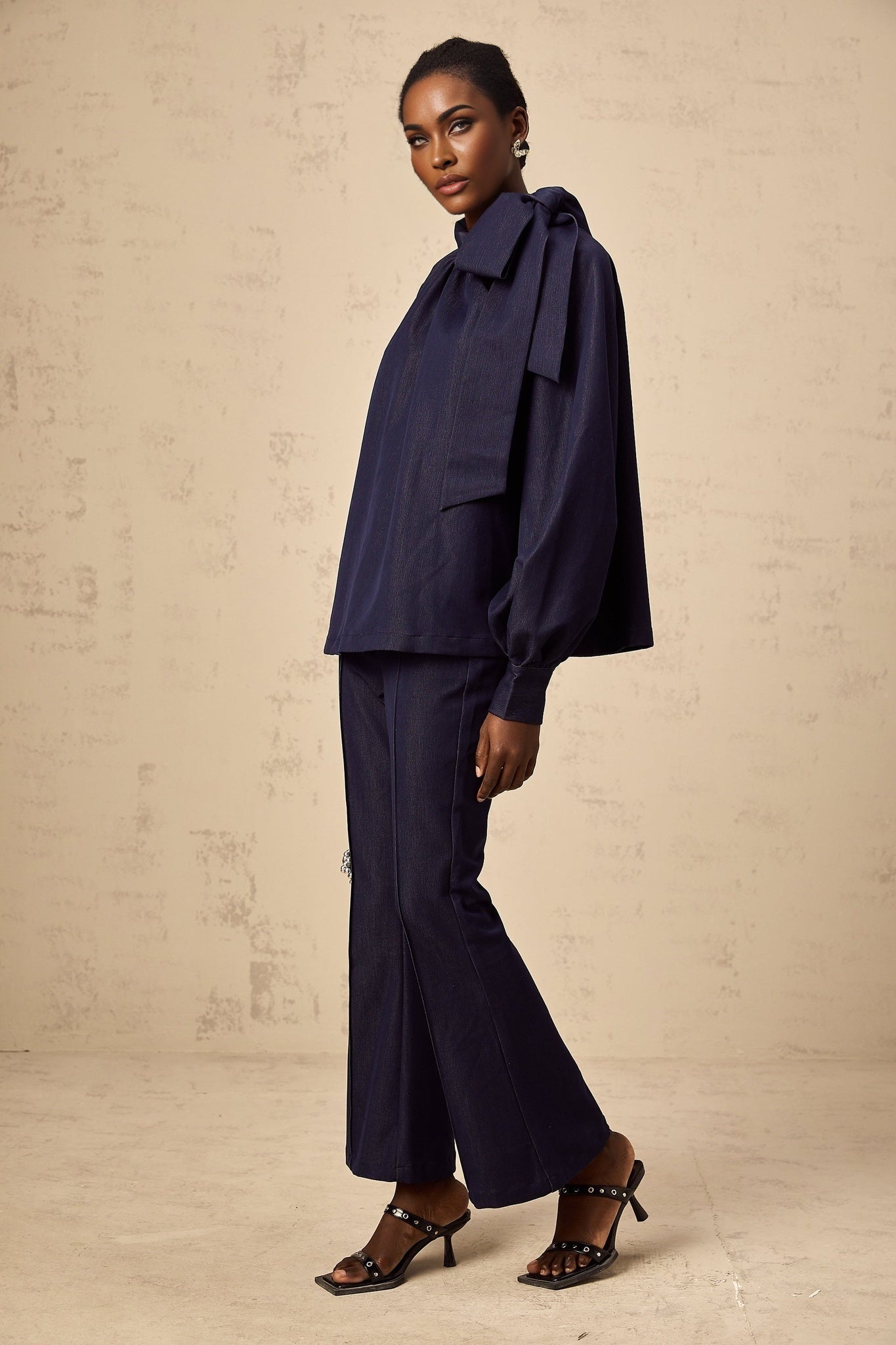Woman wearing denim blue matching set with flared blouse and trousers called Mathilde