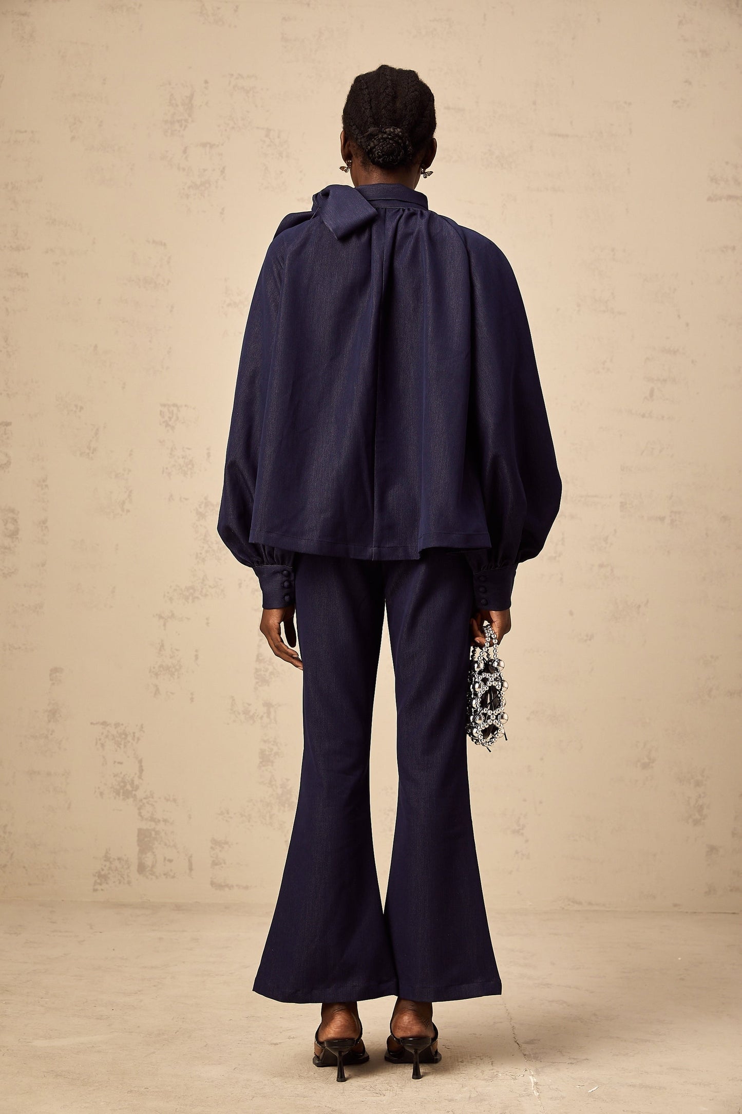 Woman wearing denim blue matching set with flared blouse and trousers called Mathilde