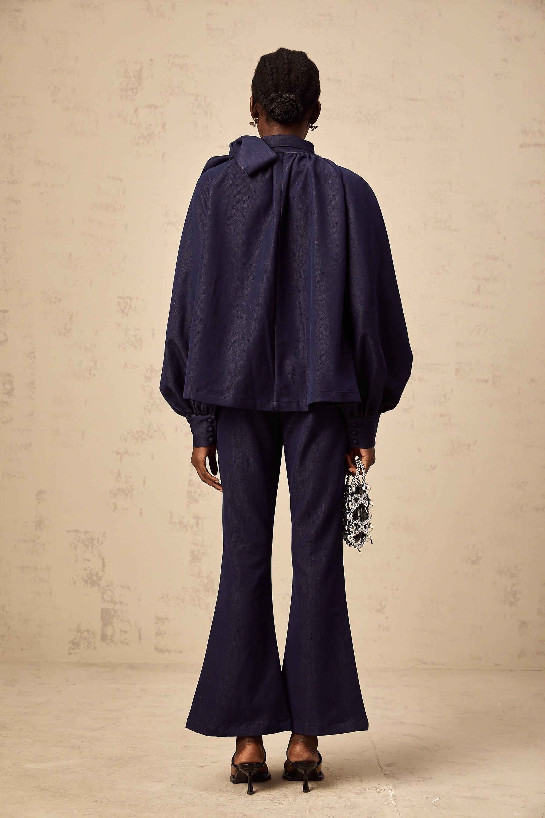 Woman wearing denim blue matching set with flared blouse and trousers called Mathilde
