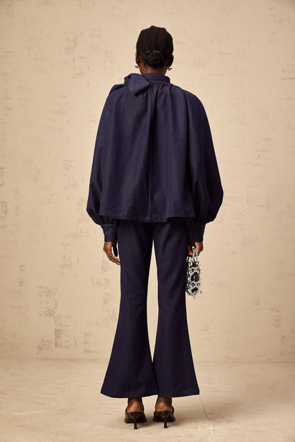 Woman wearing denim blue matching set with flared blouse and trousers called Mathilde