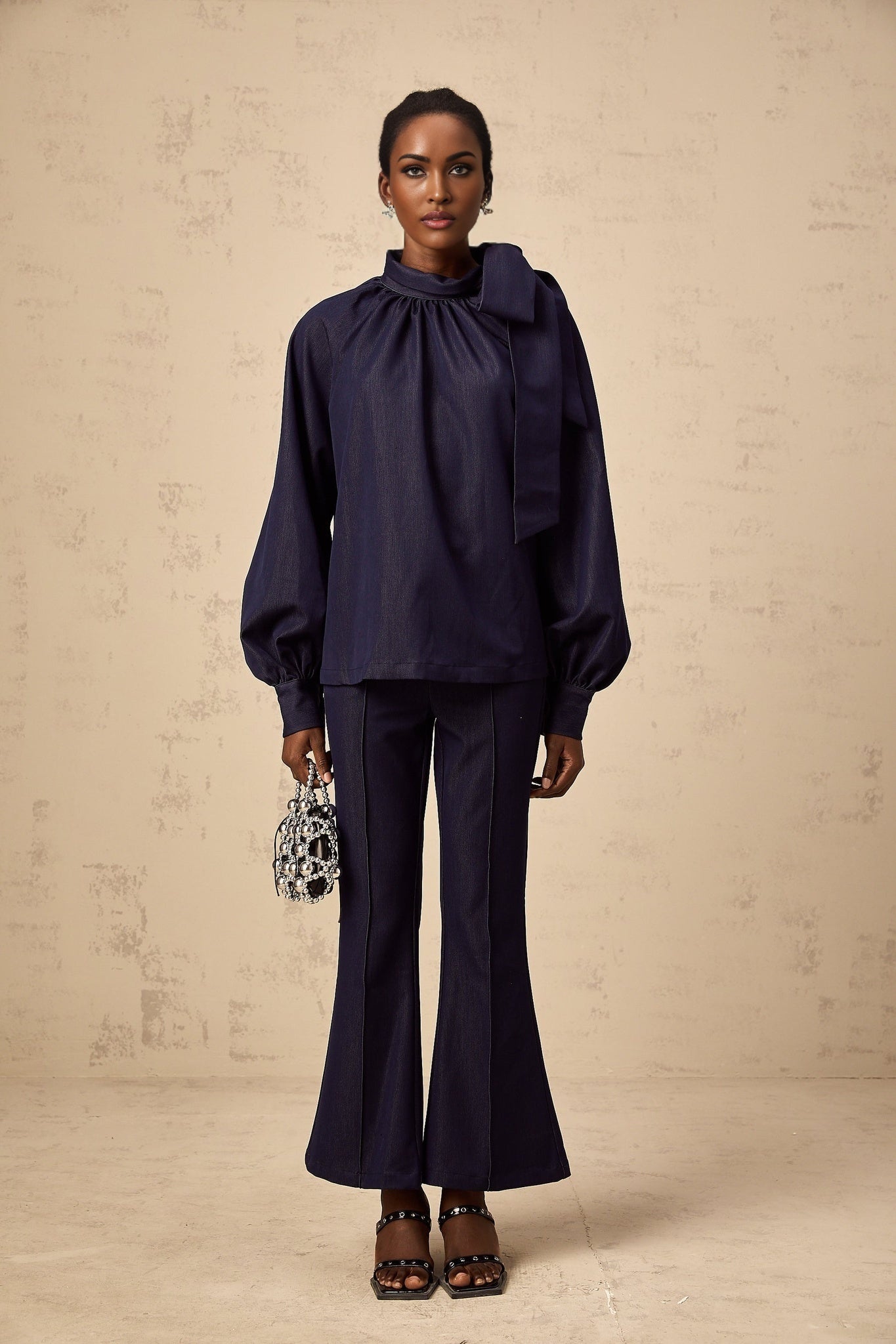 Woman wearing denim blue matching set with flared blouse and trousers named Mathilde