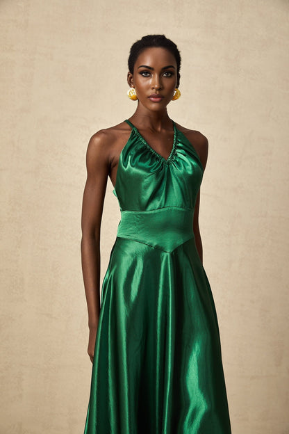 Woman wearing emerald green satin midi dress with open back detail