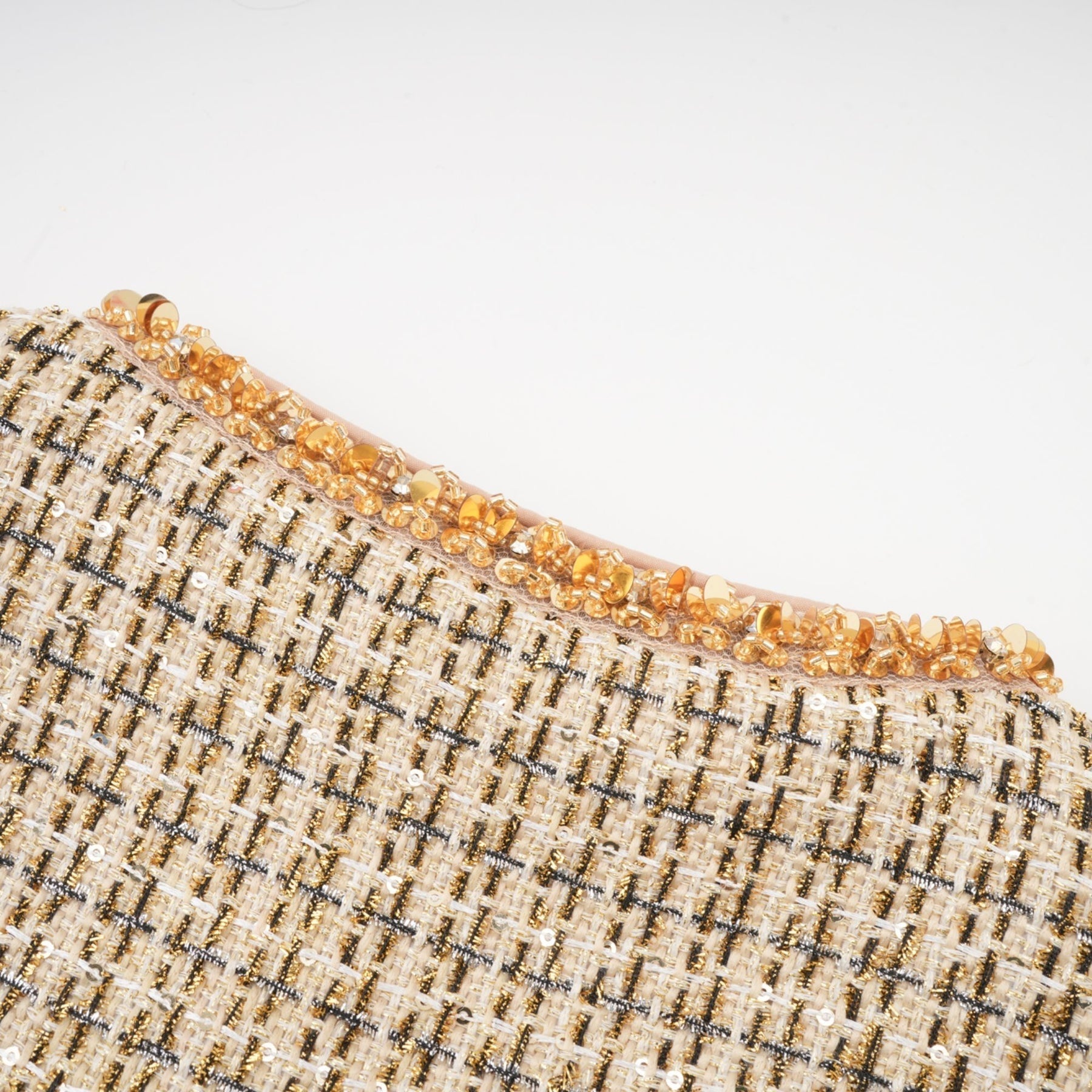 Woman wearing gold tweed jacket and matching skirt with sequin details elegant formal outfit set