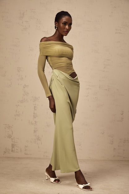 Woman wearing green off shoulder midi dress with sheer elements standing in relaxed pose