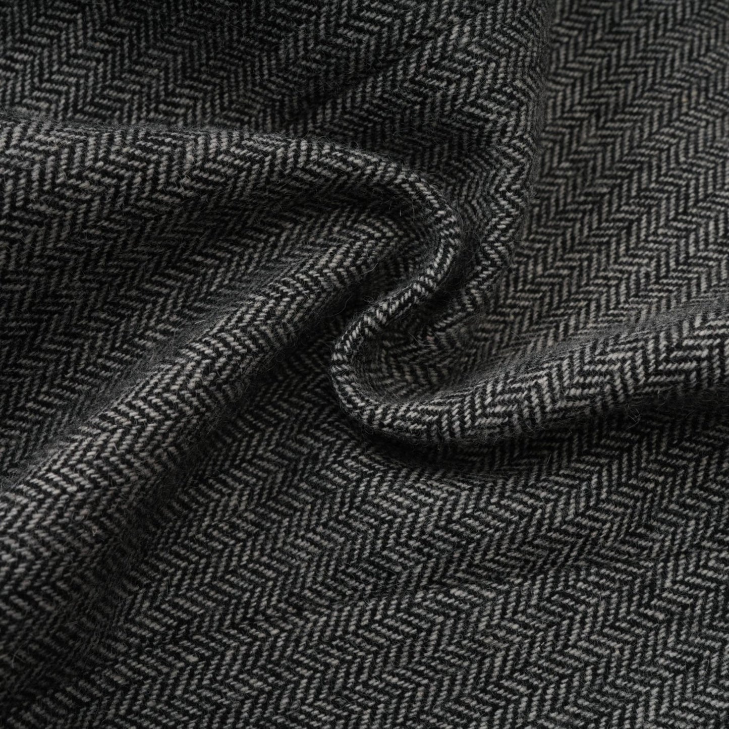 Woman wearing grey herringbone pattern matching set with top and shorts standing against plain background