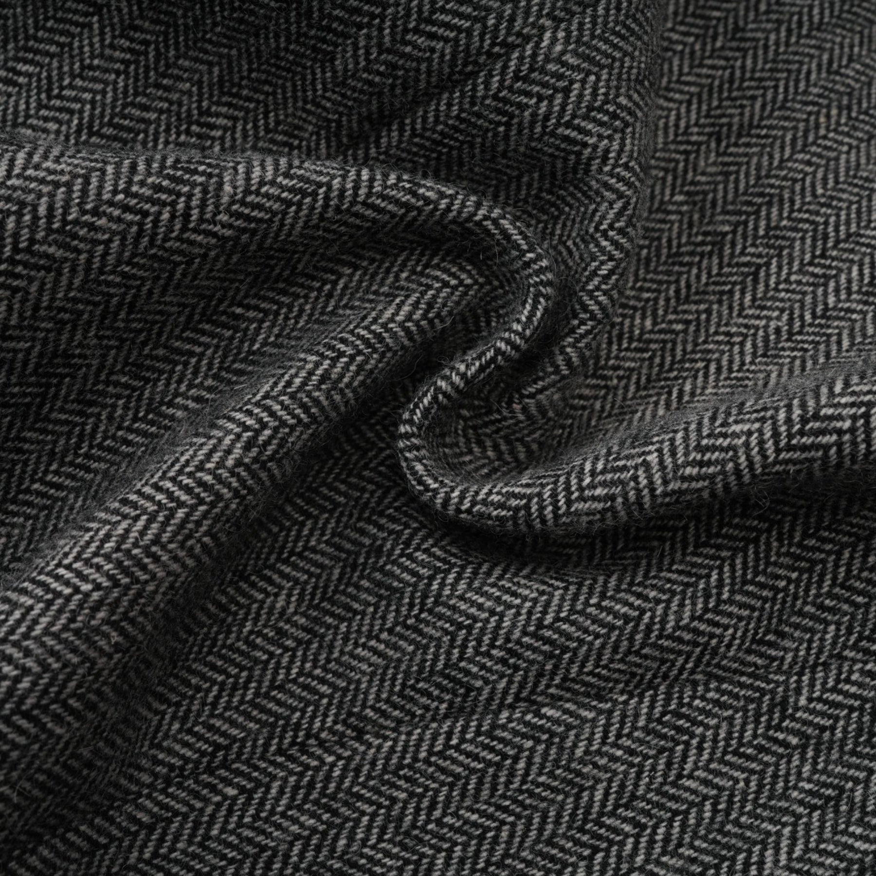Woman wearing grey herringbone pattern matching set with top and shorts standing against plain background