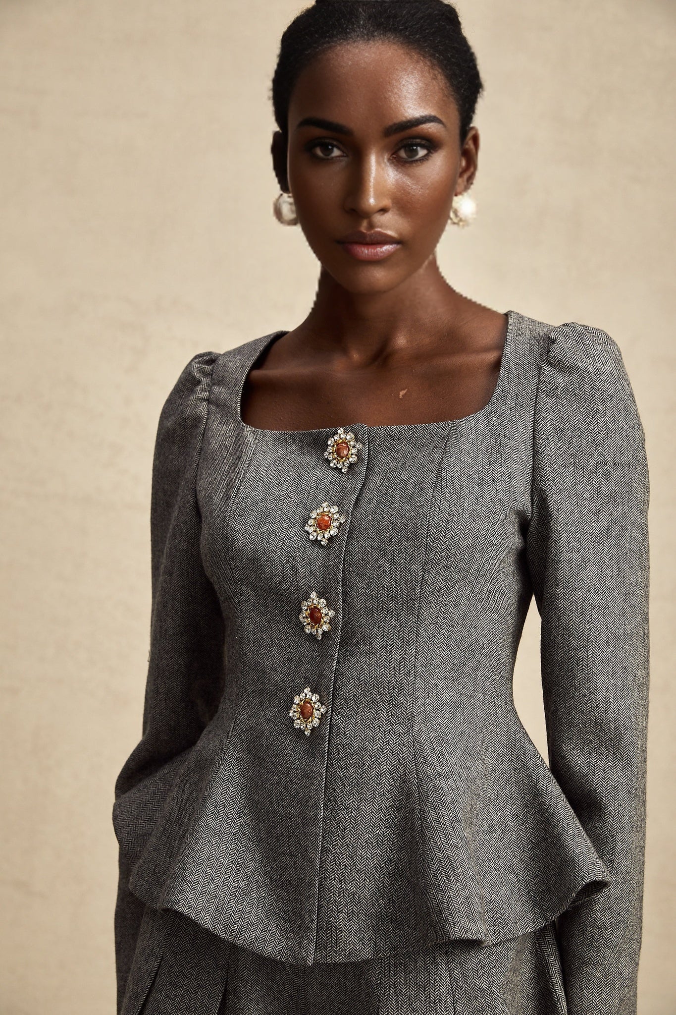 Woman wearing grey herringbone pattern matching top and shorts set named Agathe