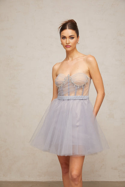 Woman wearing grey mini dress with puffed tulle sleeves and embellished details
