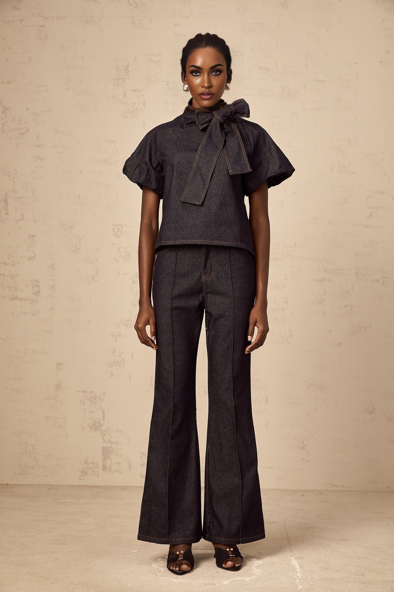 Woman wearing indigo blue denim blouse and jeans set with contrasting white stitching visible on both pieces
