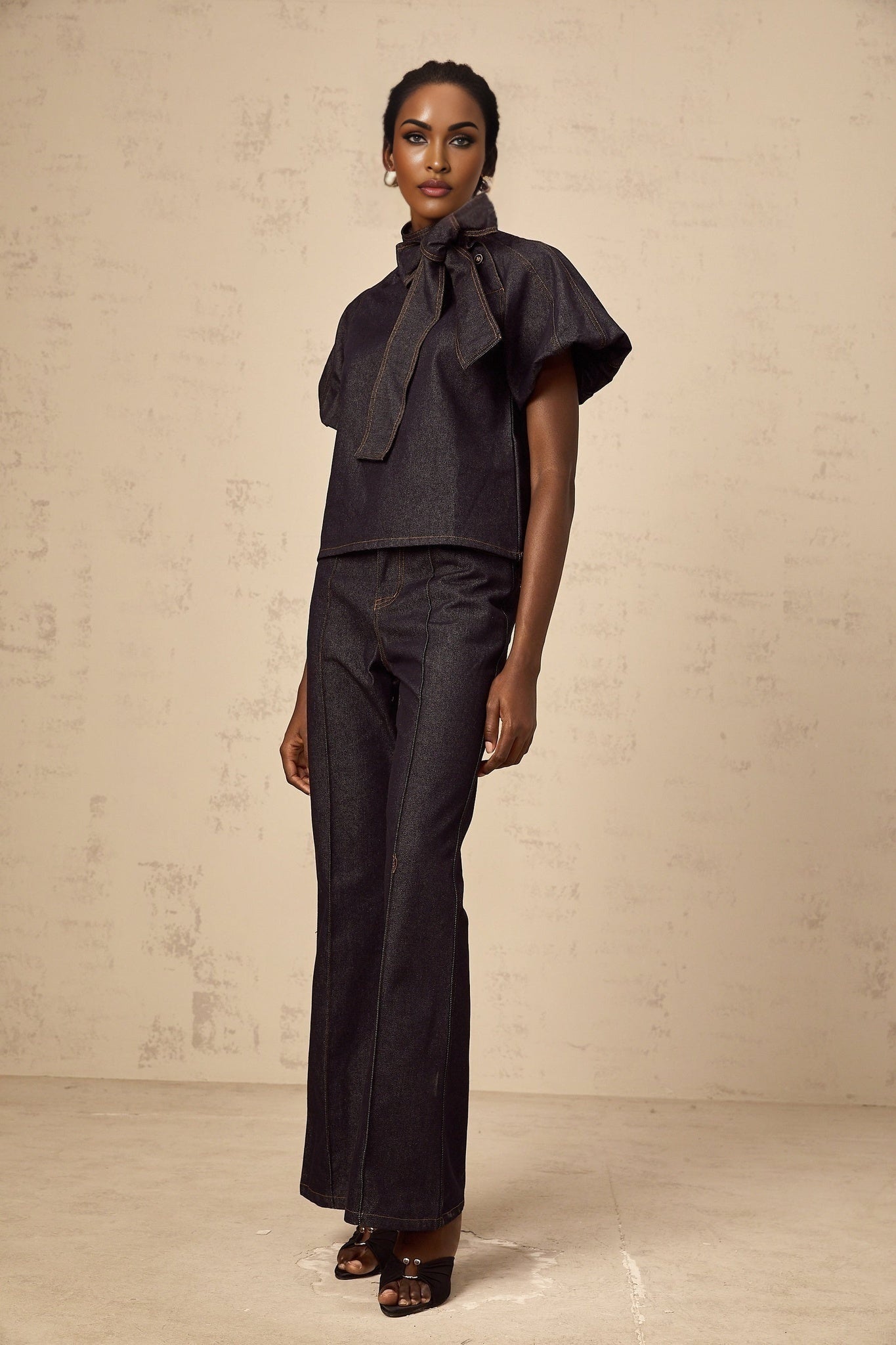 Woman wearing indigo blue denim blouse and jeans set with contrasting white stitching