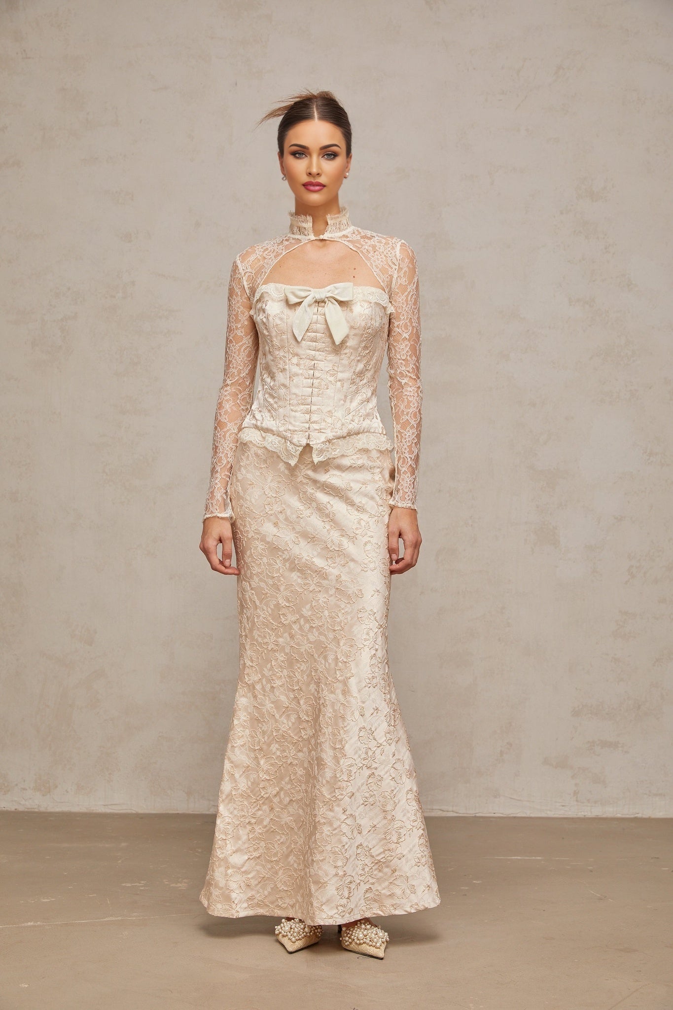 Woman wearing ivory colored matching top and skirt set with subtle patterned jacquard design