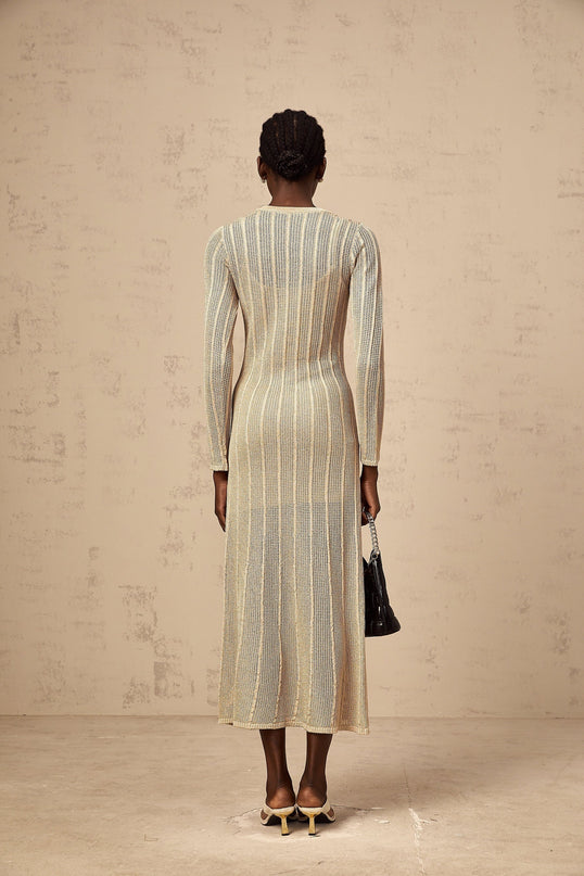 Woman wearing khaki colored fitted knit midi dress with long sleeves and form fitting silhouette