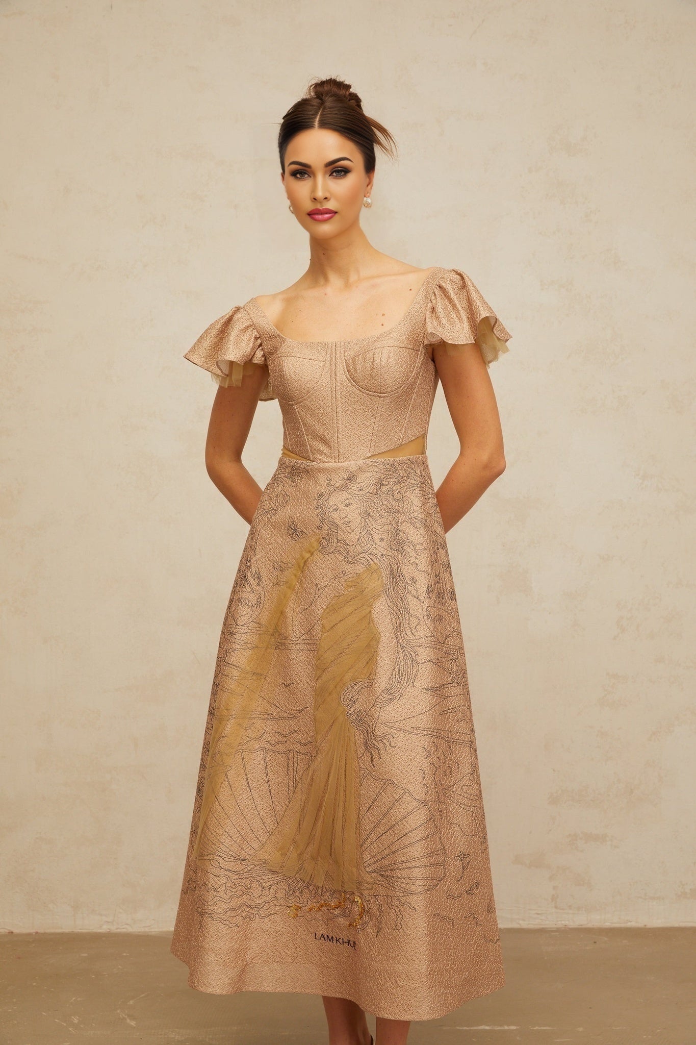 Woman wearing khaki midi dress with graphic print and flared skirt standing against plain background