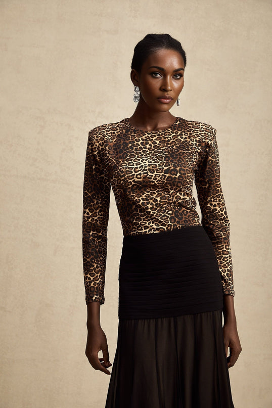 Woman wearing leopard print bodysuit with long sleeves and high neckline