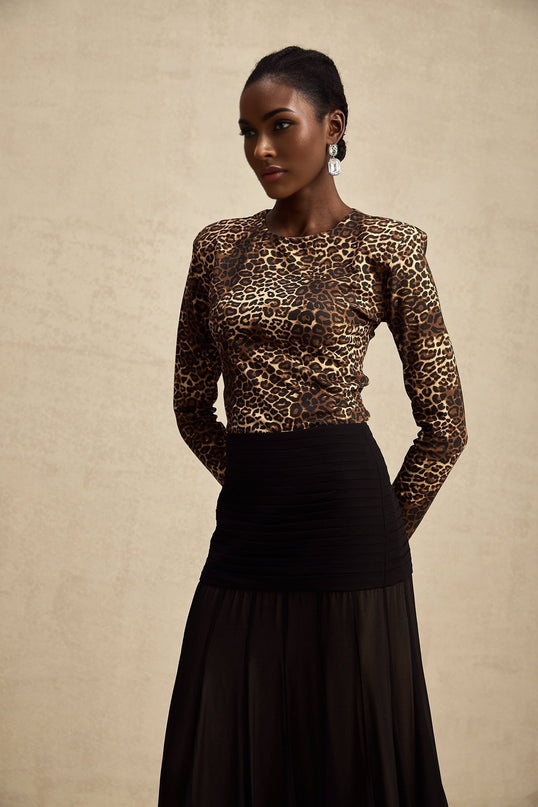 Woman wearing leopard print bodysuit with long sleeves and high neckline