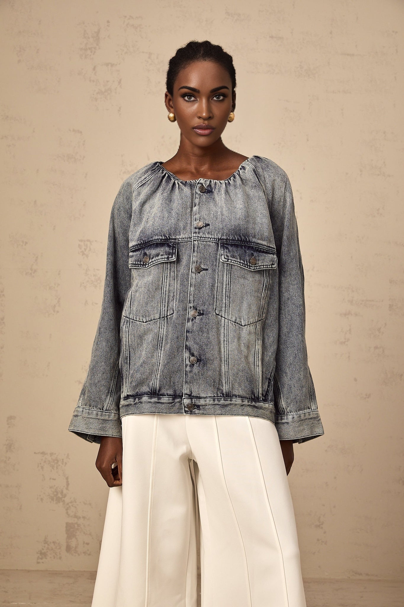 Woman wearing light blue collarless denim jacket with button front closure and chest pockets