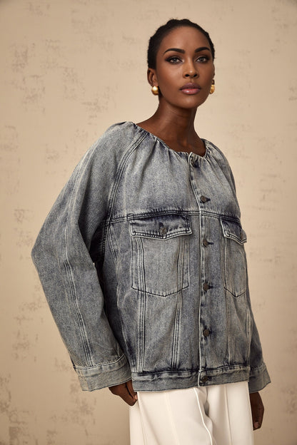 Woman wearing light blue collarless denim jacket with button front closure and chest pockets