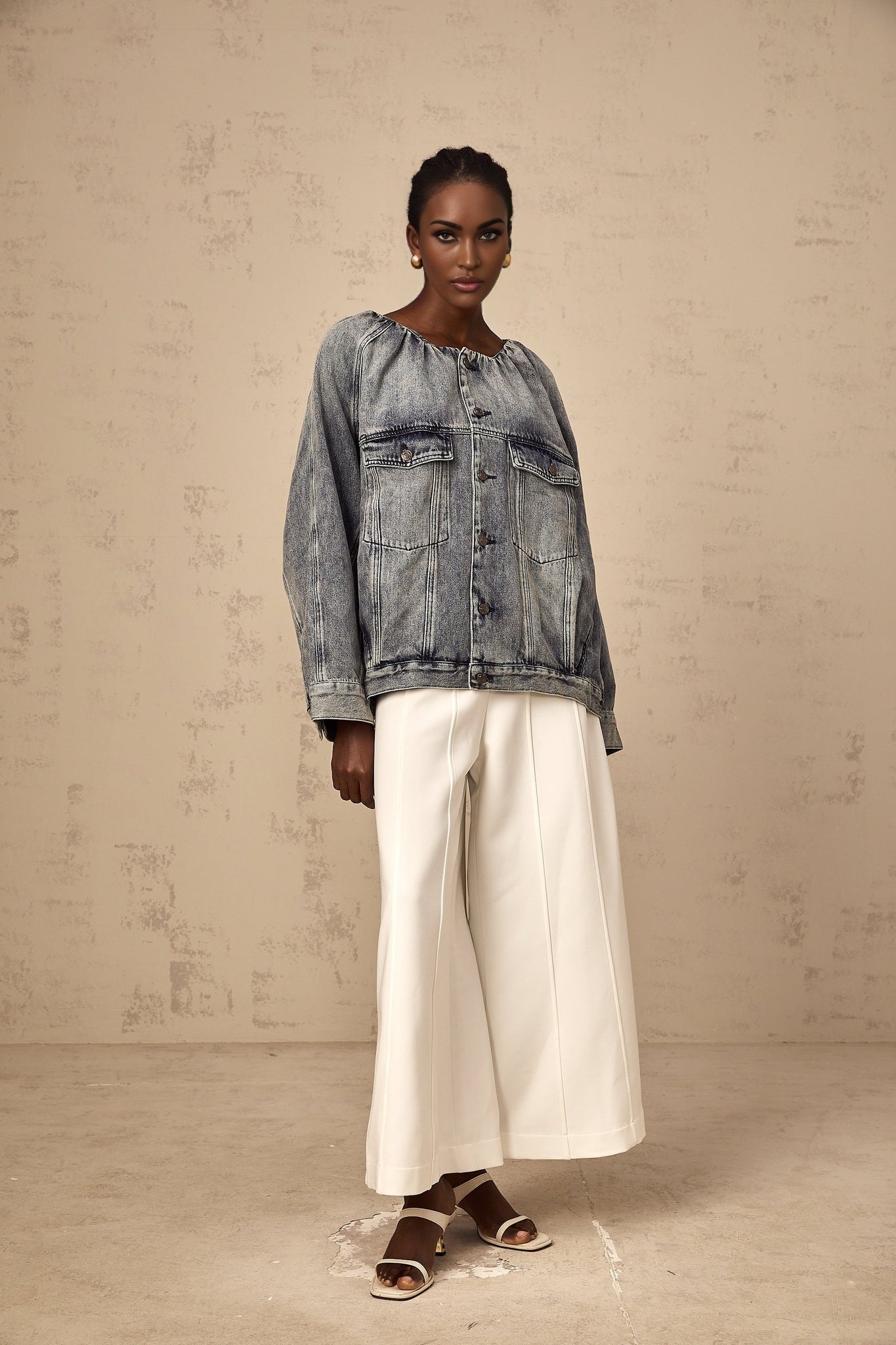 Woman wearing light blue collarless denim jacket with long sleeves and button front closure