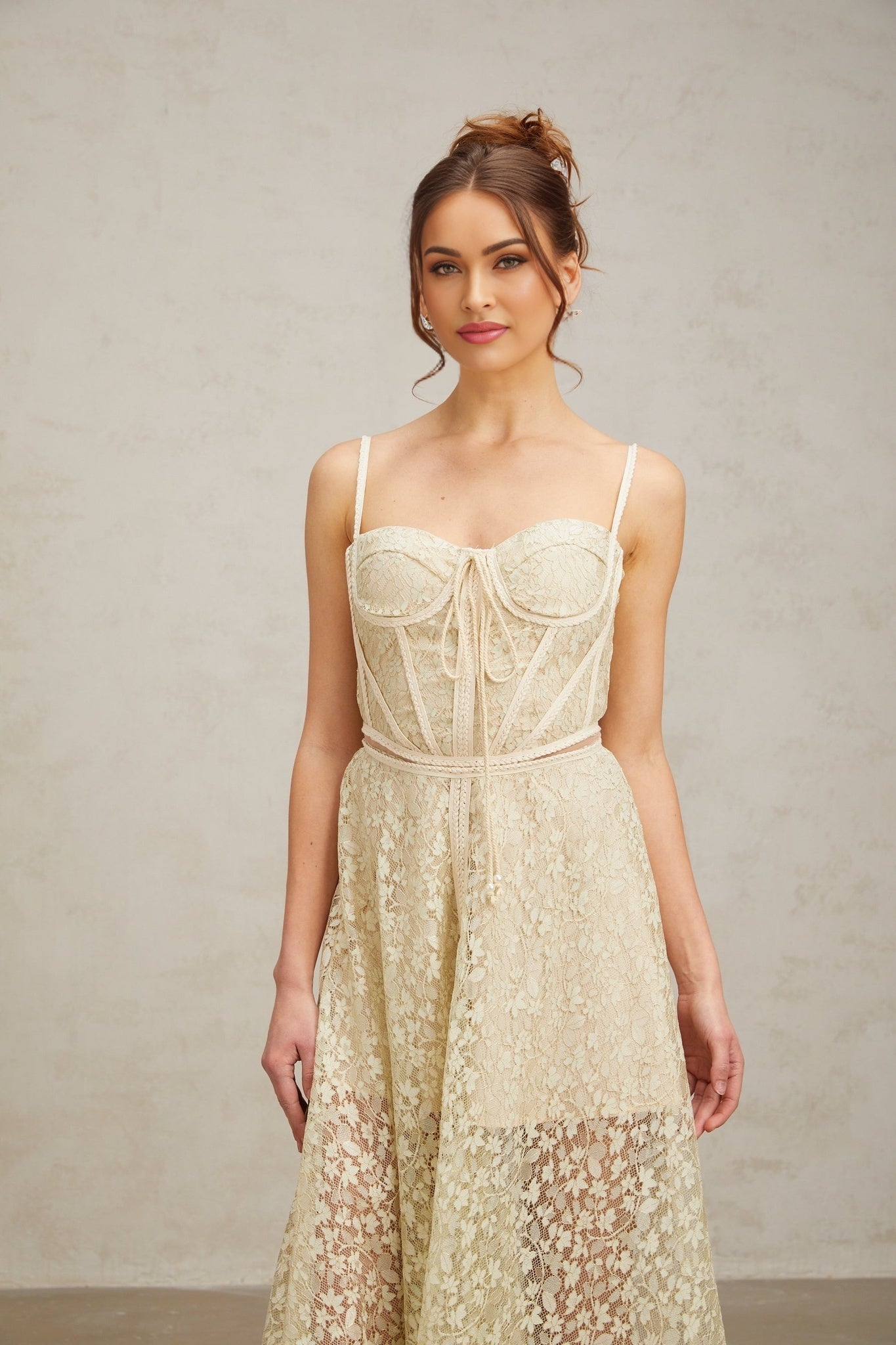 Woman wearing light green midi dress with floral embroidery pattern standing in neutral background