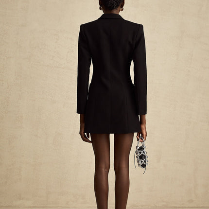 Woman wearing long black blazer dress with lapels and single button closure