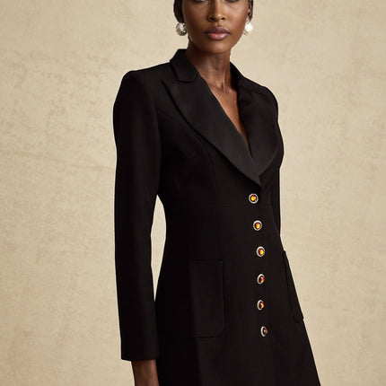 Woman wearing long black blazer dress with single button closure and lapel collar
