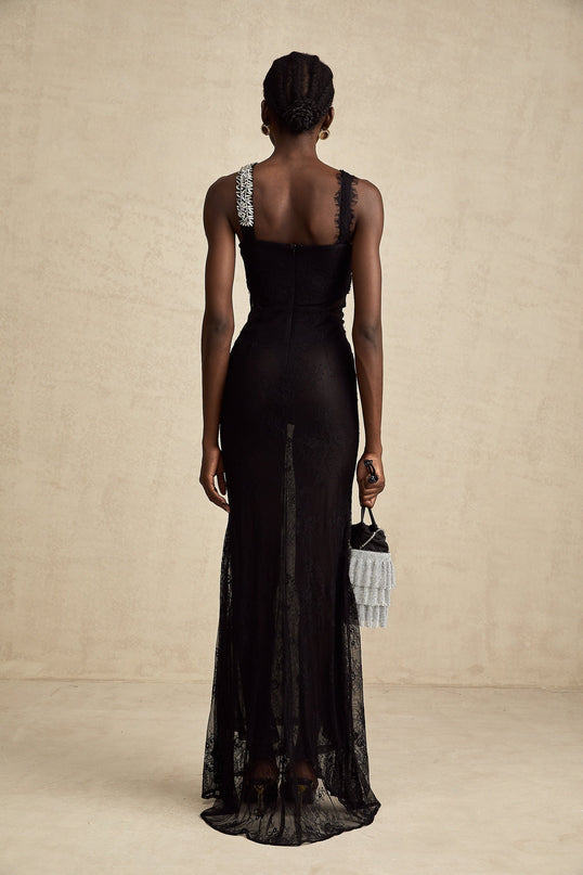 Woman wearing long black evening gown with crystal embellishments and crossover neckline