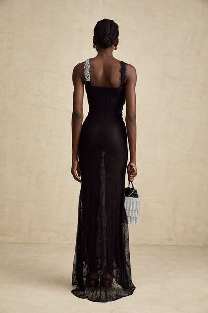 Woman wearing long black evening gown with crystal embellishments and crossover neckline