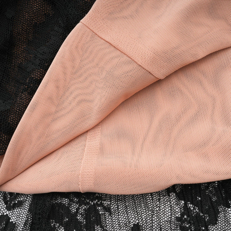 Woman wearing long black lace maxi dress with flared skirt and fitted bodice