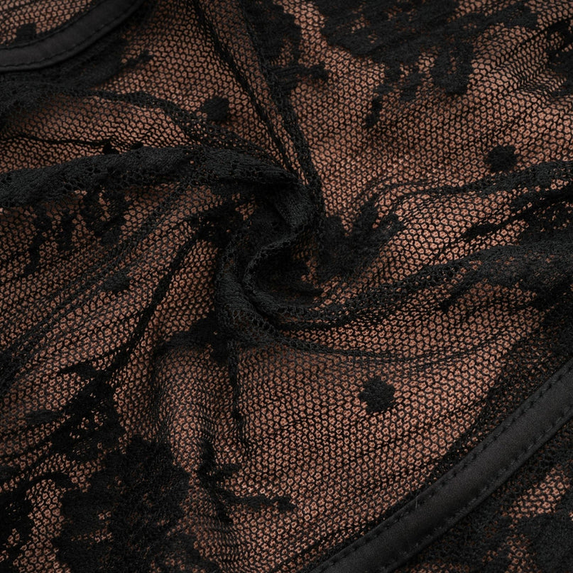 Woman wearing long black lace maxi dress with flared skirt and fitted bodice