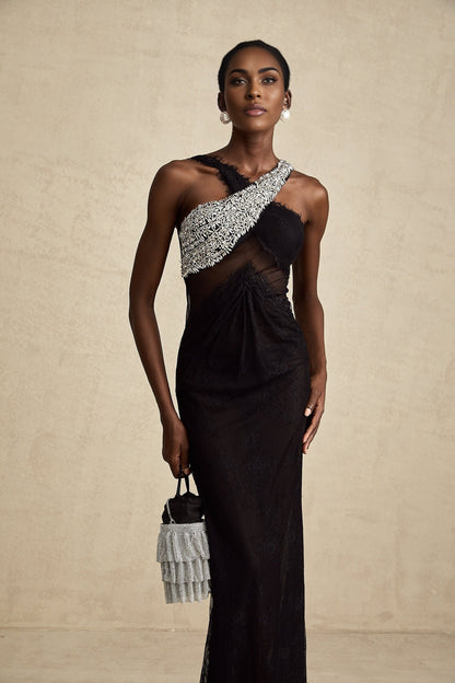 Woman wearing long black maxi dress with crossover bodice and crystal embellishments