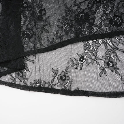 Woman wearing long black maxi dress with crystal embellishments and crossover design