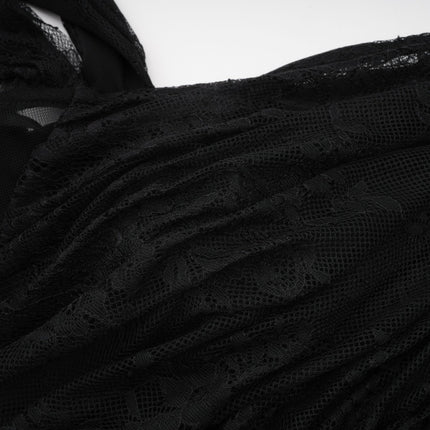 Woman wearing long black maxi dress with one shoulder strap and side cutout detail