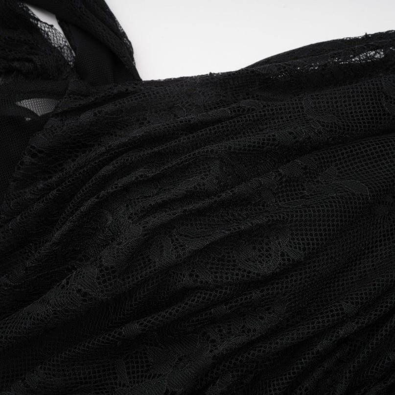 Woman wearing long black maxi dress with one shoulder strap and side cutout detail