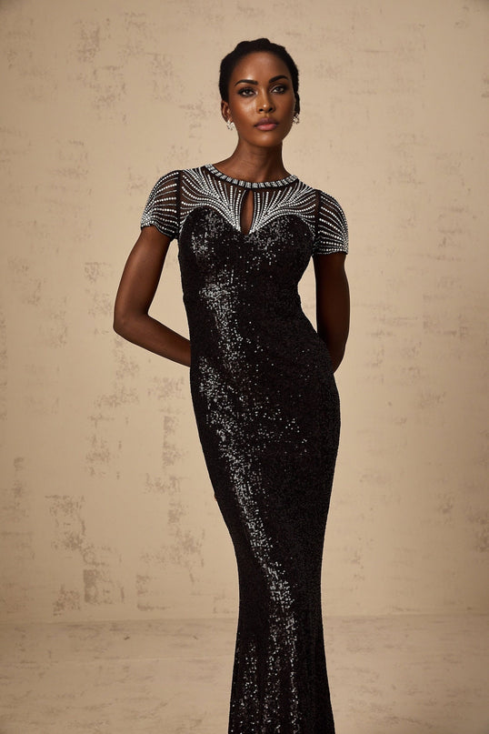 Woman wearing long black sequined maxi dress with cutout detail