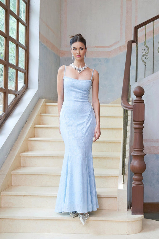 Woman wearing long blue floral jacquard maxi dress with laceup front and flared skirt