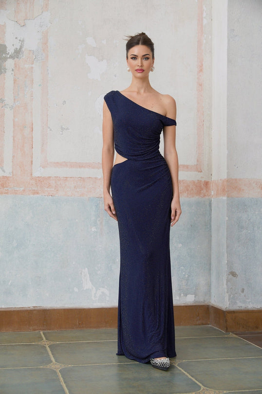 Woman wearing long blue maxi dress with rhinestone details and cut out sections
