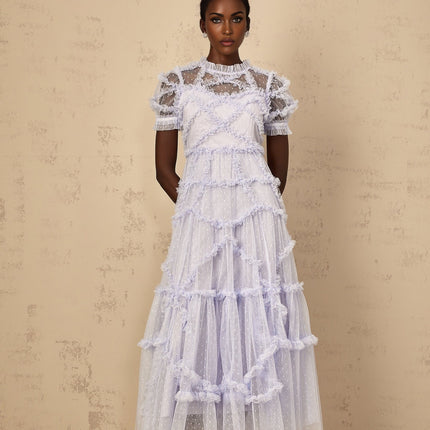 Woman wearing long blue maxi dress with white polka dots and ruffled tulle details