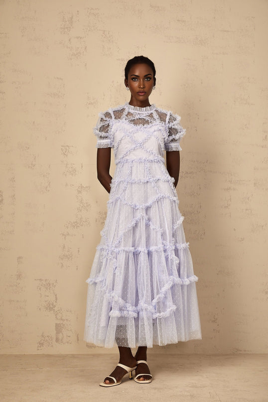 Woman wearing long blue maxi dress with white polka dots and ruffled tulle details