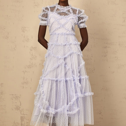 Woman wearing long blue maxi dress with white polka dots and ruffled tulle details